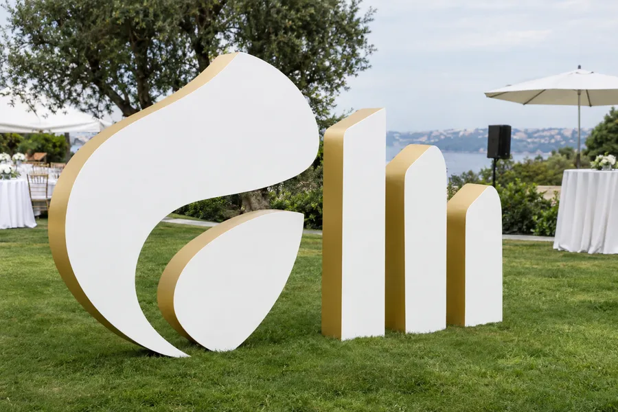 Concept image of carved EPS foam dimensional shapes, painted white with gold edges, on a lawn at an event.