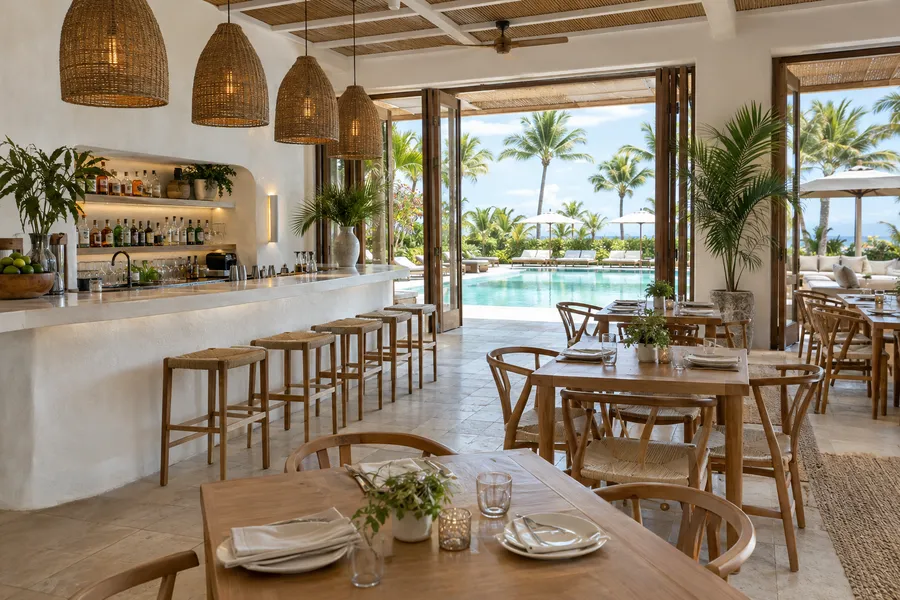 Concept image of a resort poolside restaurant with a white plaster bar, woven pendants, teak chairs and palms.