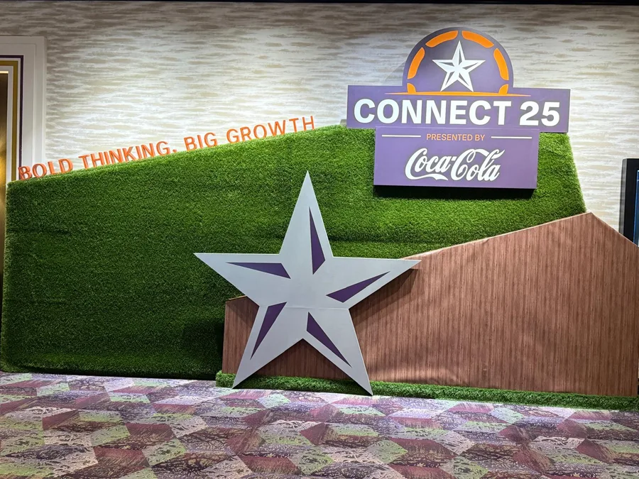 A Connect 25 turf wall with a large dimensional star, wood-look panel and Coca-Cola sign.