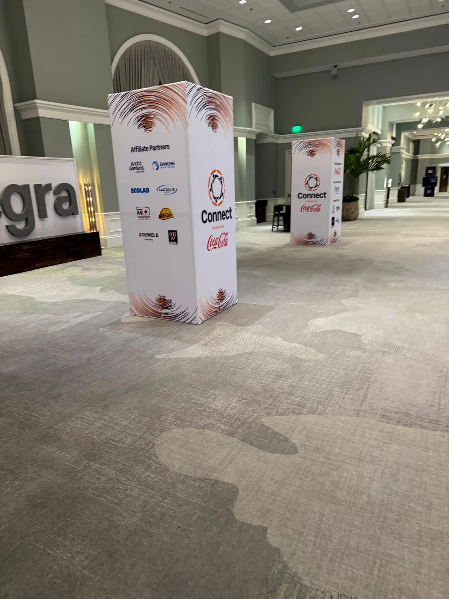 Entegra branded partner towers and a dimensional logo sign in a hotel ballroom foyer.